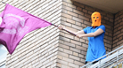 A supporter of feminist punk band Pussy Riot wearing the group's trademark colored balaclava waves a flag on a balcony in Moscow on Friday. A supporter of feminist punk band Pussy Riot wearing the group's trademark colored balaclava waves a flag on a balcony in Moscow on Friday.
