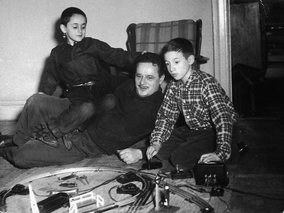 Abel Meeropol watches as his sons, Robert and Michael, play with a train set.