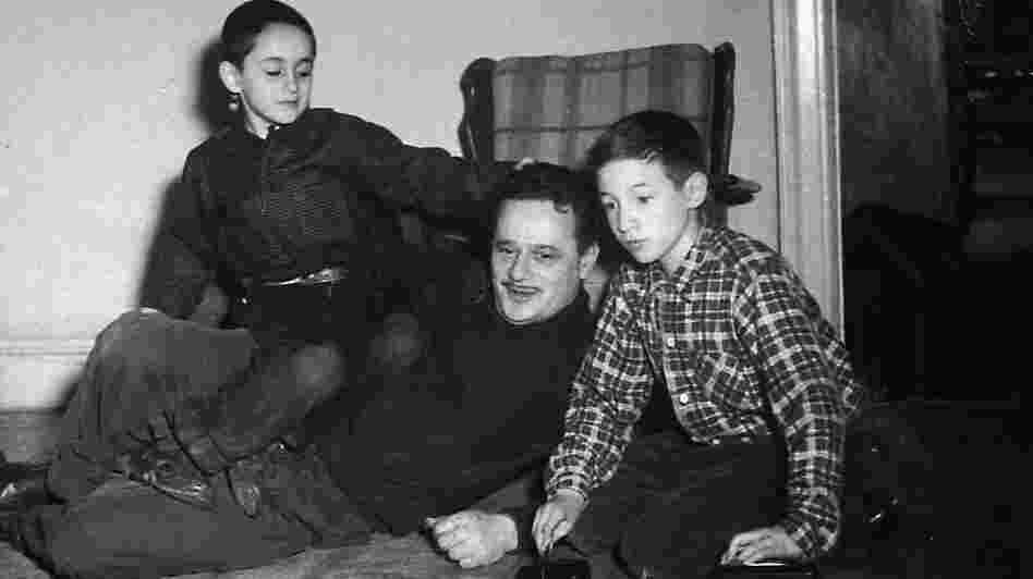 Abel Meeropol watches as his sons, Robert and Michael, play with a train set.