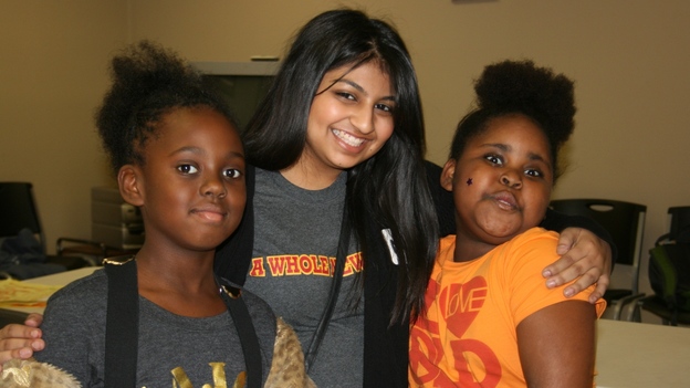 Austin College student Naureen Dharani, center, with new friends at an afterschool program.