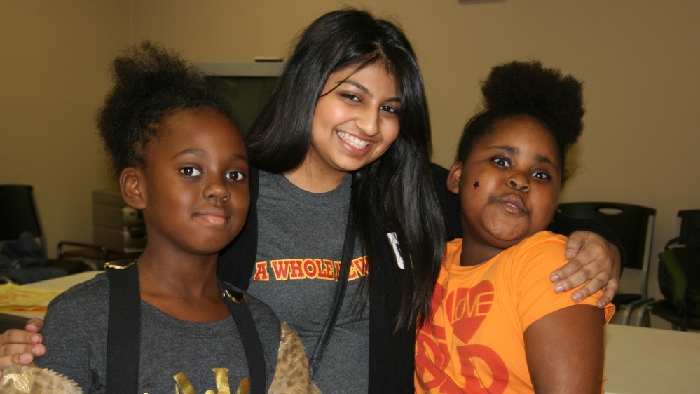 Austin College student Naureen Dharani, center, with new friends at an afterschool program.