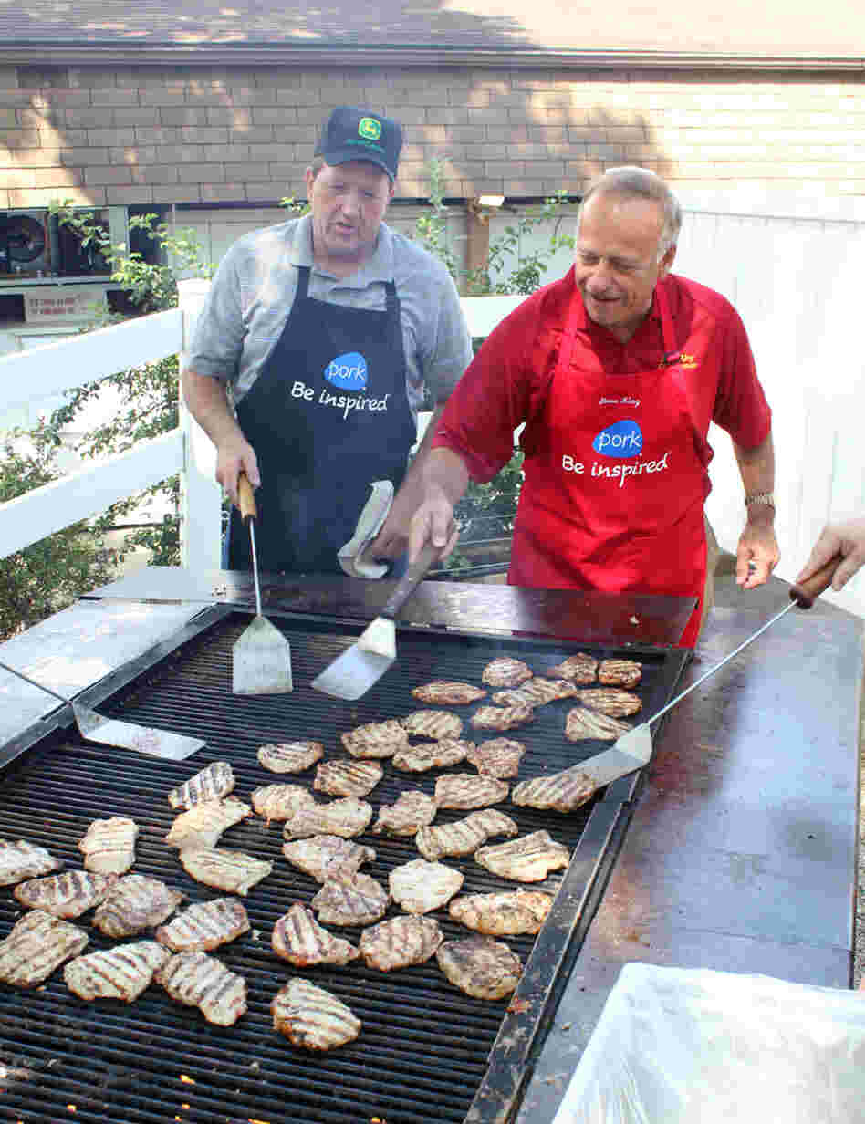 Republican Rep. Steve King of Iowa (right) flips pork chops at the Iowa State Fair in Des Moines while Terry Aupperle of Wiota watches. Aupperle lives in Cass County. He can't vote for King anymore because of redistricting.