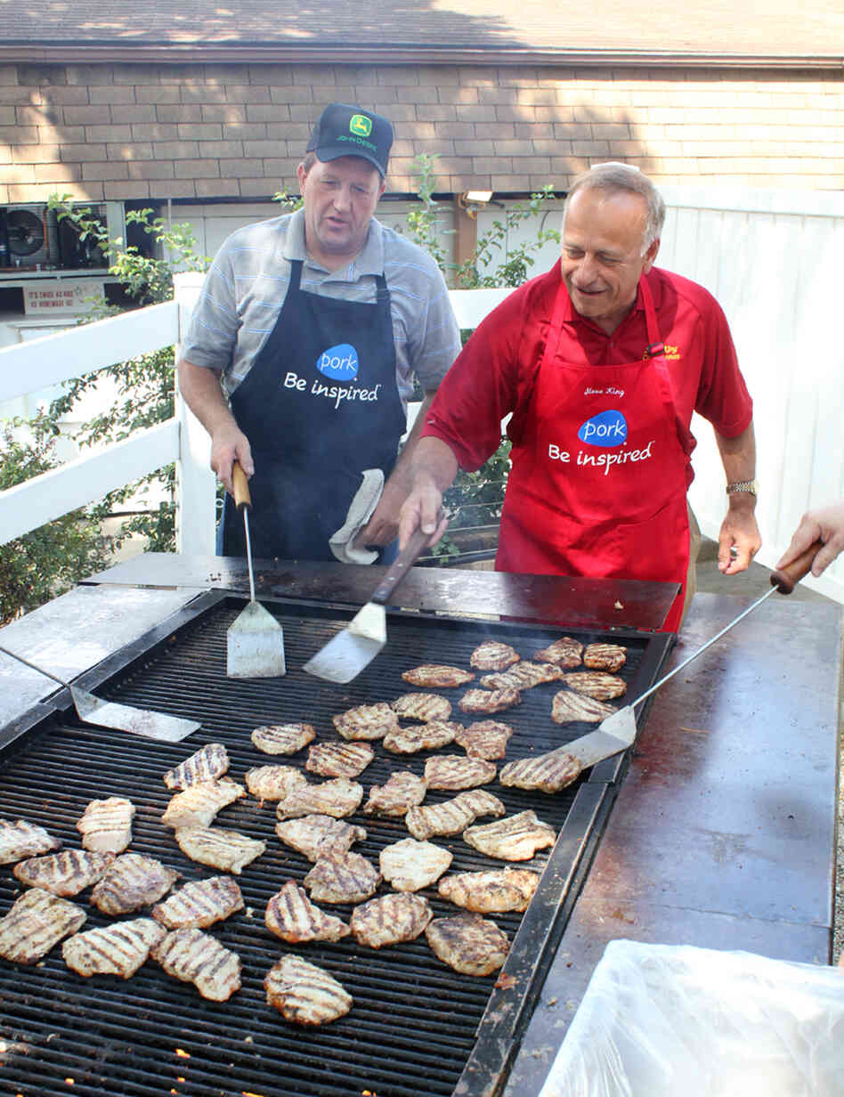 Republican Rep. Steve King of Iowa (right) flips pork chops at the Iowa State Fair in Des Moines while Terry Aupperle of Wiota watches. Aupperle lives in Cass County. He can't vote for King anymore because of redistricting.