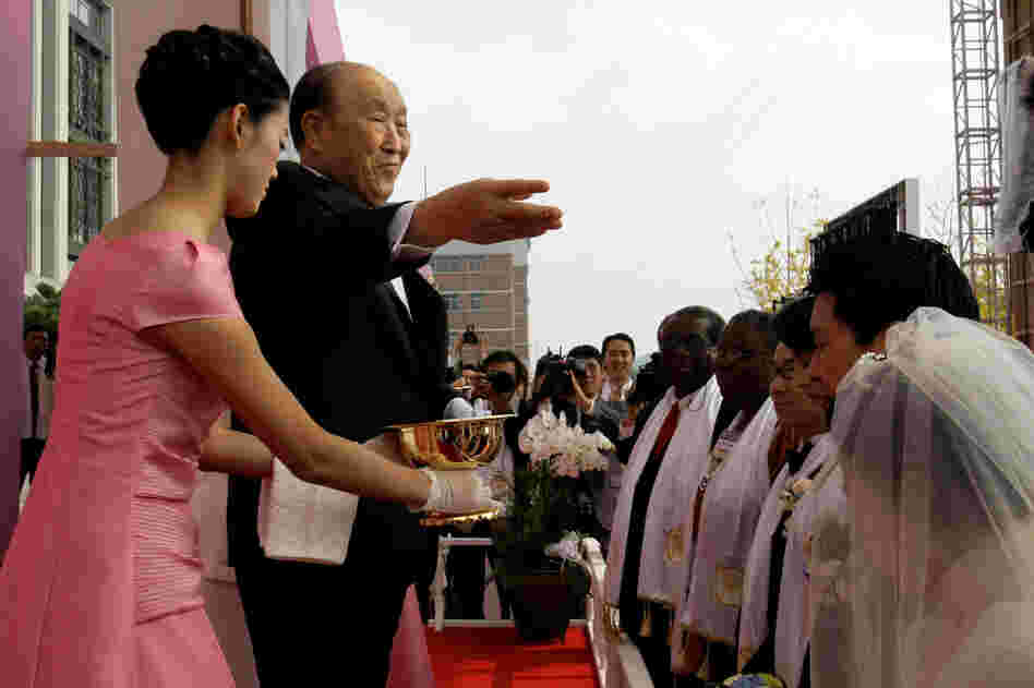 Moon spreads holy waters during a mass wedding ceremony arranged by his Unification Church at Sun Moon University in Asan, south of Seoul, South Korea, in October 2009.