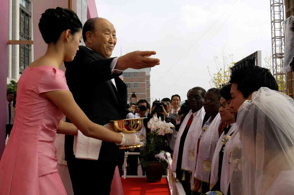 Moon spreads holy waters during a mass wedding ceremony arranged by his Unification Church at Sun Moon University in Asan, south of Seoul, South Korea, in October 2009.