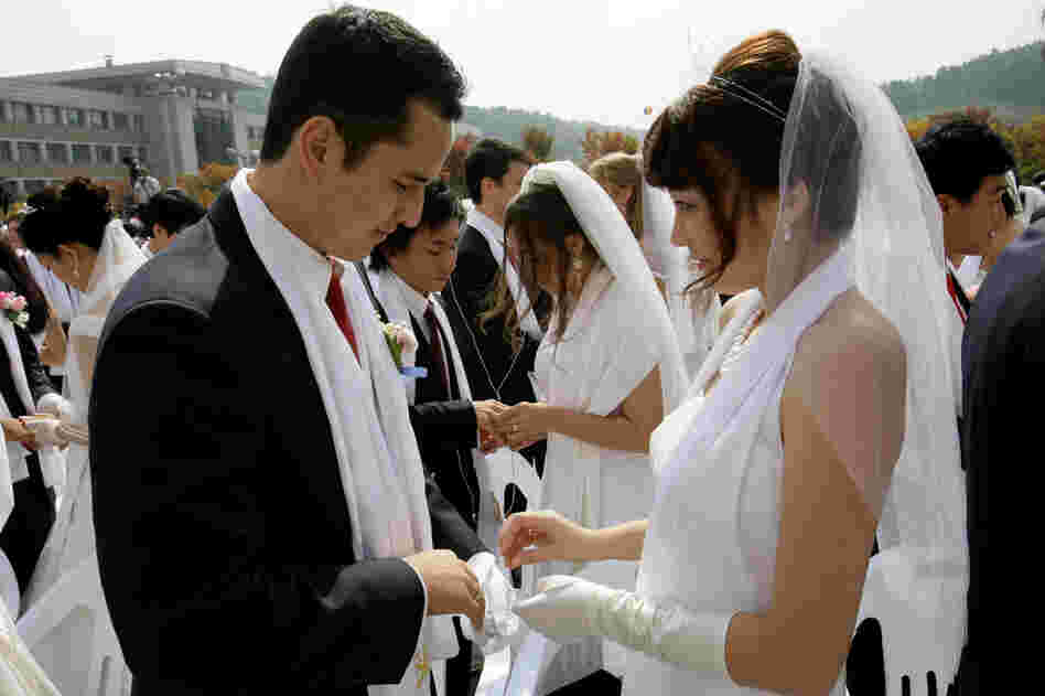 Bridegroom Uriah Buscovich from California and his bride, Moona Field from Argentina, exchange their wedding rings during the mass wedding ceremony.