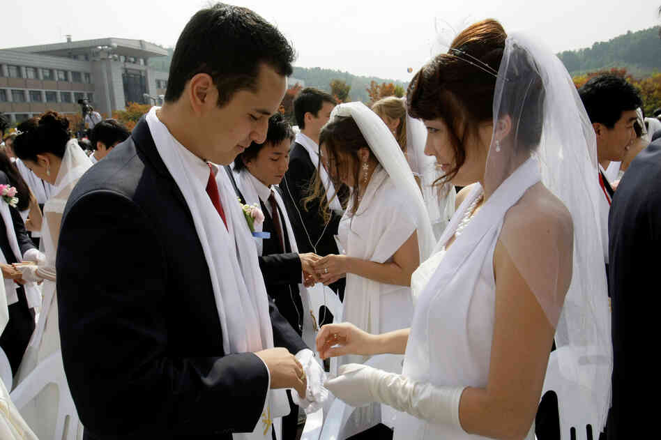 Bridegroom Uriah Buscovich from California and his bride, Moona Field from Argentina, exchange their wedding rings during the mass wedding ceremony.