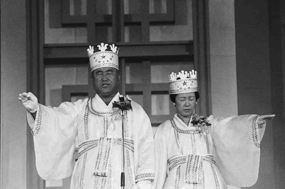 Moon and his wife participate in the traditional invocation of a blessing at a mass wedding in Seoul's Chamsil gymnasium, where 6,000 couples from about 80 countries were married in 1982.