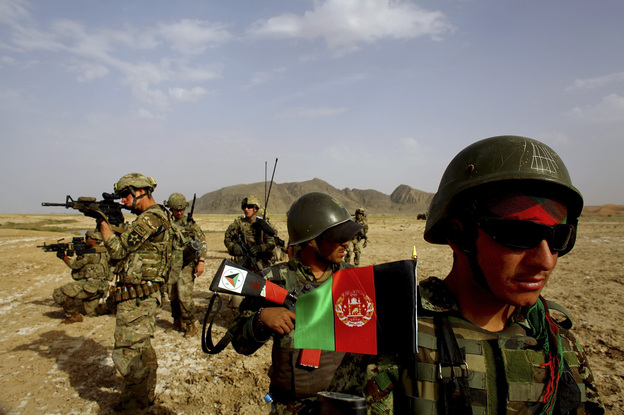 Afghan soldiers (right) patrol with U.S. troops in the Panjwai district of southern Afghanistan in May. The two armies have been working together for years, but Afghan attacks against U.S. and NATO forces have been rising recently.
