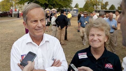 Rep. Todd Akin, R-Mo., and his wife Lulli, talk with reporters last Thursday at the Missouri State Fair in Sedalia, Mo. On Monday, Akin was resisting GOP calls to resign from his Senate race.