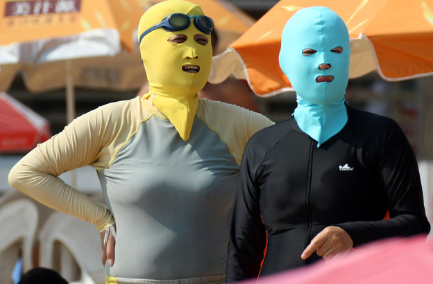 Chinese beachgoers wear face-kinis in Qingdao, northeast China's Shandong province. The face masks allow people to enjoy the water and sand — but not the effects of the sun.