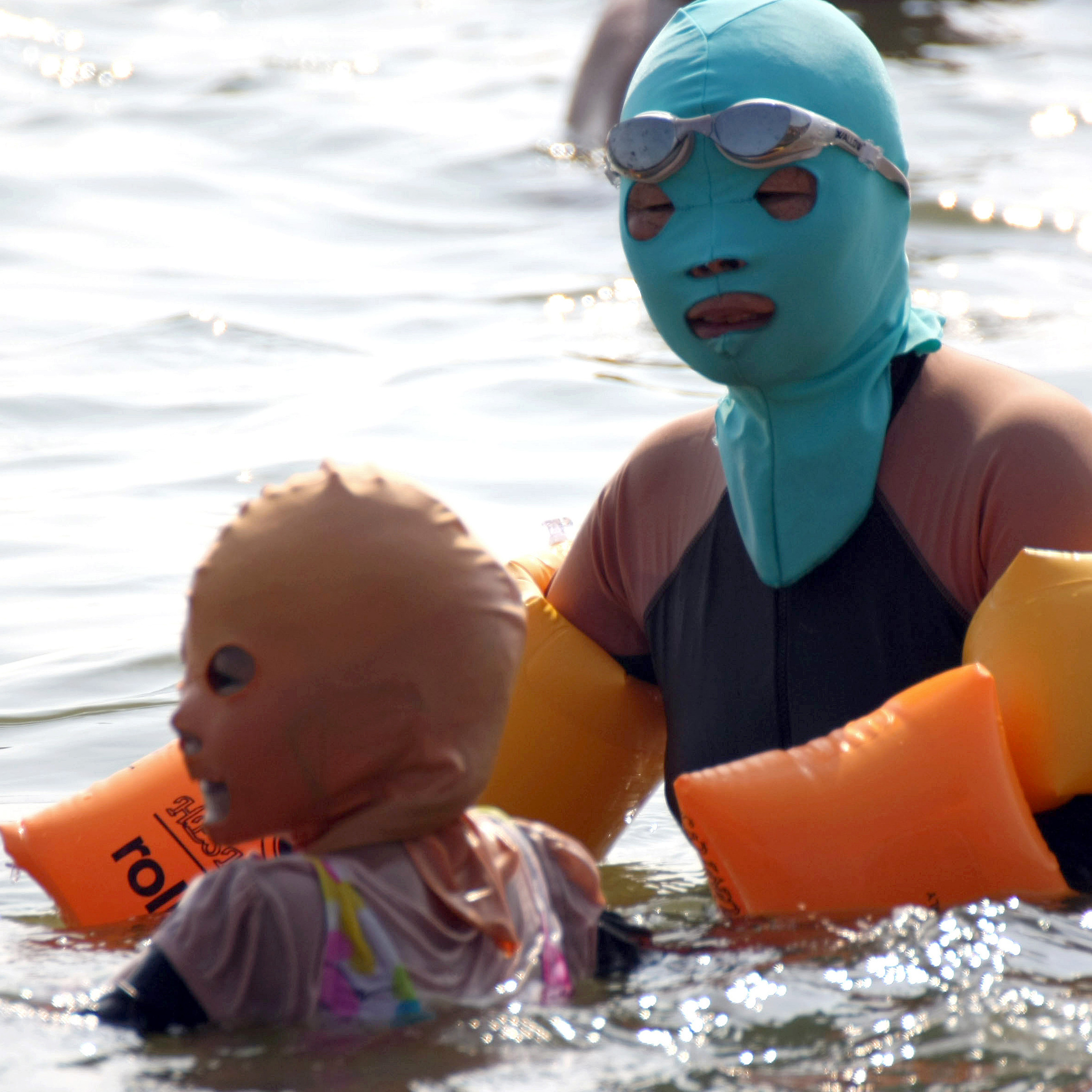 Chinese swimmers wear face-kinis at the public Huiquan Beach in Qingdao, on China's eastern coast.