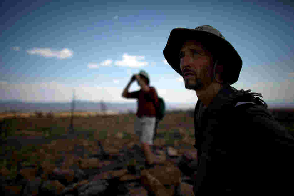 Allen (left) and Castro look across the wasteland of a plateau reduced to ashes during the Las Conchas fire. Because the fires stripped vegetation from hillsides, these areas are now vulnerable to flash floods during the summer rains.