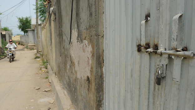In the Islamabad slum where a Christian girl is accused of burning some Muslim verses, the gate to her family's home is locked and the people who live there have fled.