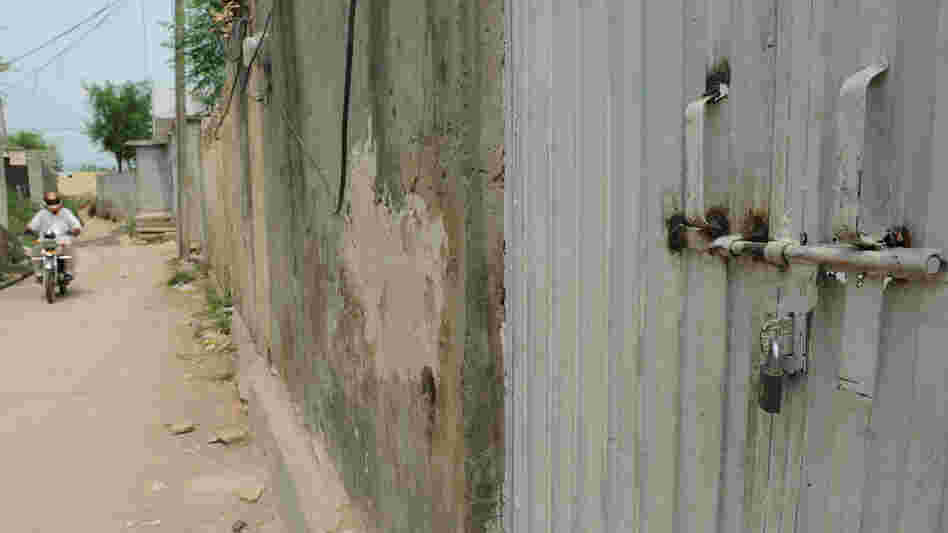 In the Islamabad slum where a Christian girl is accused of burning some Muslim verses, the gate to her family's home is locked and the people who live there have fled.