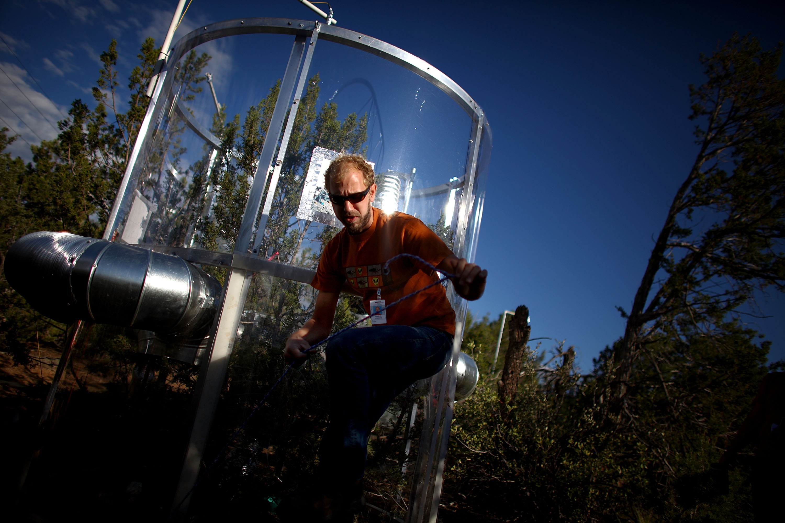 Heath Powers climbs through a maze of wiring at the 