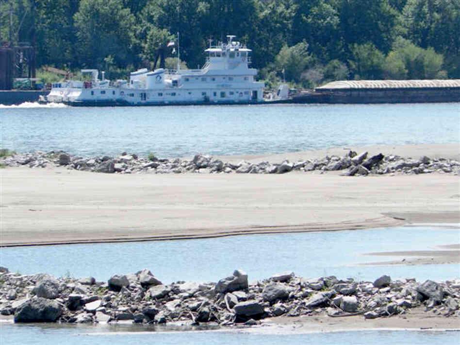 A tow pushes a barge past a sandbar on the Mississippi River near the confluence with the Missouri River north of St. Louis., on Friday. Many sandbars normally under water on the two rivers are now exposed as the drought has caused river levels to drop.