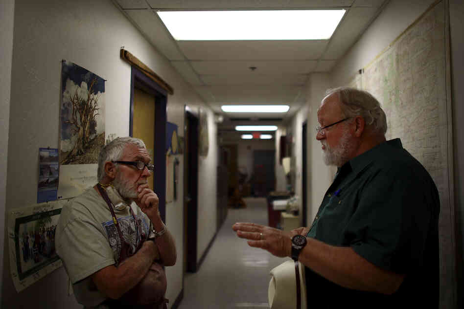 Adams (left) talks with Swetnam in their laboratory, nestled under the football stadium.