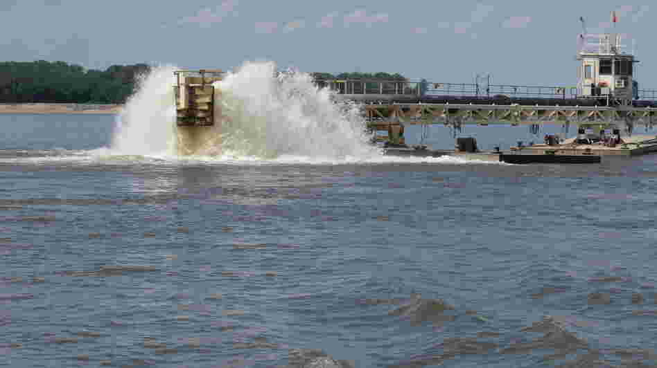 Water gets churned up at the end of a dredging pipeline connected to a U.S. Army Corps of Engineers dredge on the Mississippi River near Memphis, Tenn., on Monday. The river has seen water levels from Illinois to Louisiana plummet because of drought conditions in the past three months. When there's less flow coming downstream, saltwater from the Gulf wedges its way in.