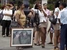 People, one holding an image of Cuba's President Raul Castro and his brother Fidel Castro, wait in line at a bus stop in Havana last month. People, one holding an image of Cuba's President Raul Castro and his brother Fidel Castro, wait in line at a bus stop in Havana last month.