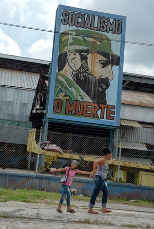 Cubans pass by a billboard celebrating the 86th birthday of former Cuban President Fidel Castro, on August 13, 2012 in Havana. Castro celebrated his birthday quietly and out of the public eye, while political allies and Cuban citizens paid tribute from afar.