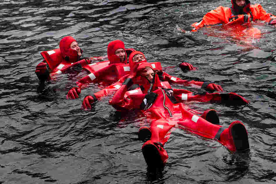 In a formation called "the worm," crewmen link up to be able to paddle against strong waves and winds to a lifeboat.