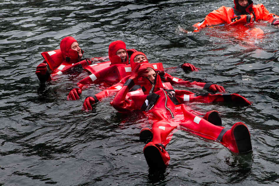 In a formation called "the worm," crewmen link up to be able to paddle against strong waves and winds to a lifeboat.