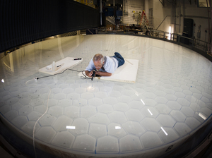 Angel does a final inspection on one of his mirrors. The weight of telescope mirrors made the traditional way limits their size. Angel realized he could produce a bigger mirror by creating a mold with a honeycomb pattern, making the mirror lighter.