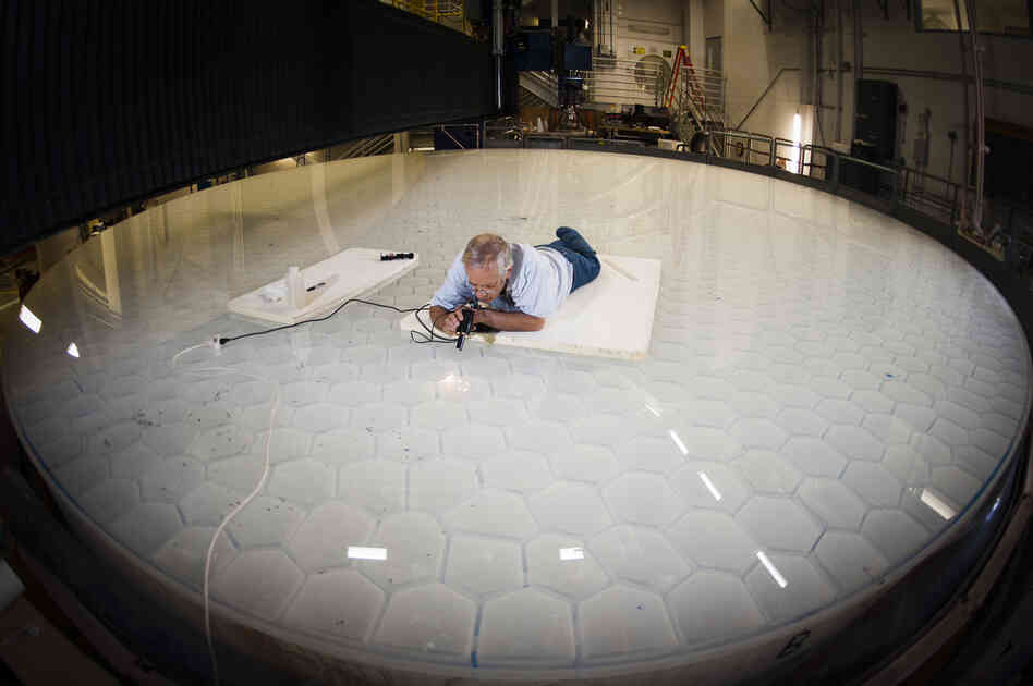Angel does a final inspection on one of his mirrors. The weight of telescope mirrors made the traditional way limits their size. Angel realized he could produce a bigger mirror by creating a mold with a honeycomb pattern, making the mirror lighter.