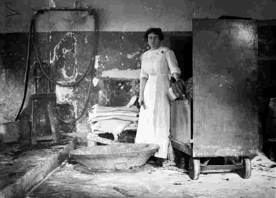 A woman identified as "Miss Louise Lester" holds a stack of damaged bills, circa 1909. These were thrown down a chute, foreground, and recycled into paper pulp. A woman identified as "Miss Louise Lester" holds a stack of damaged bills, circa 1909. These were thrown down a chute, foreground, and recycled into paper pulp.