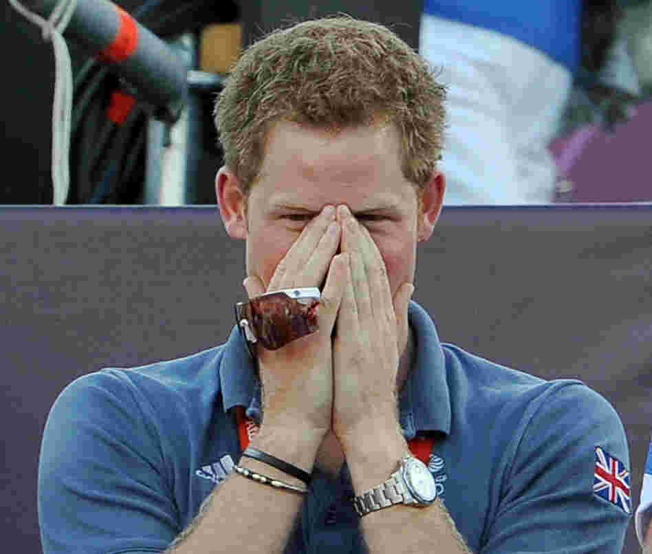Prince Harry, fully clothed, watching a beach volleyball match at the Olympic Games in London on Aug. 8.