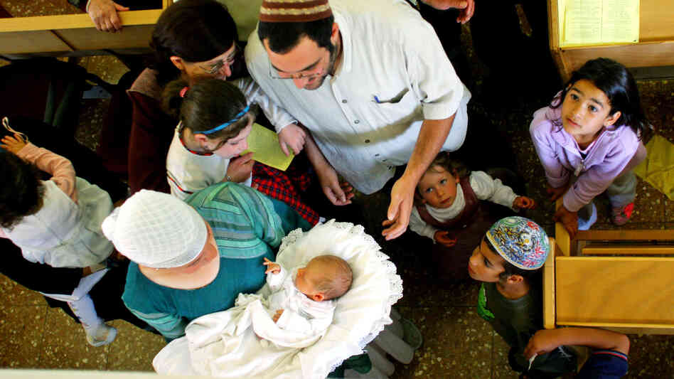 Family members and friends gather around 8-day-old Israeli baby Oz Naftaly Cohen after his traditional Jewish circumcision ceremony in 2005.