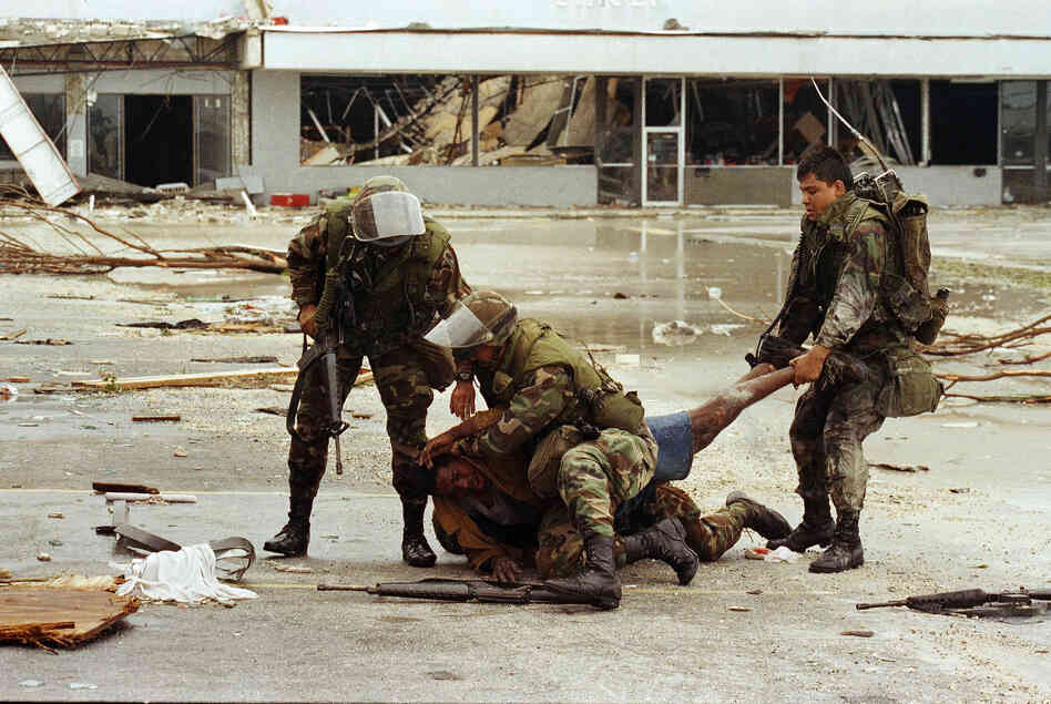 Members of the Florida National Guard subdue a man outside the Cutler Ridge shoe store. The unidentified man, carrying a firearm, was wrestled to the ground after guard members thought he was looting the store. 