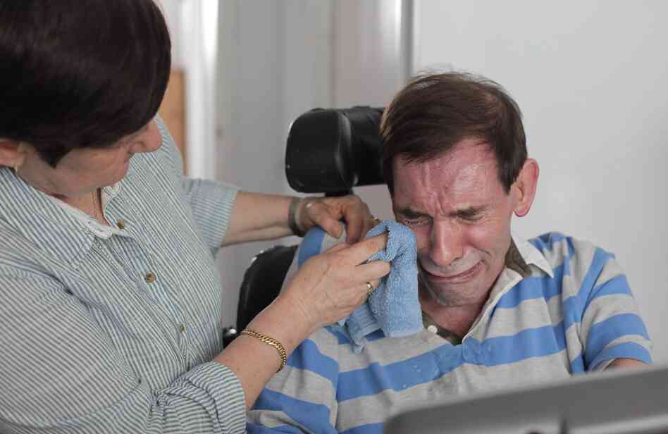 Tony Nicklinson's wife, Jane, wipes his tears as he learns that a court has denied him the right to medically assisted suicide on Aug. 16, 2012.