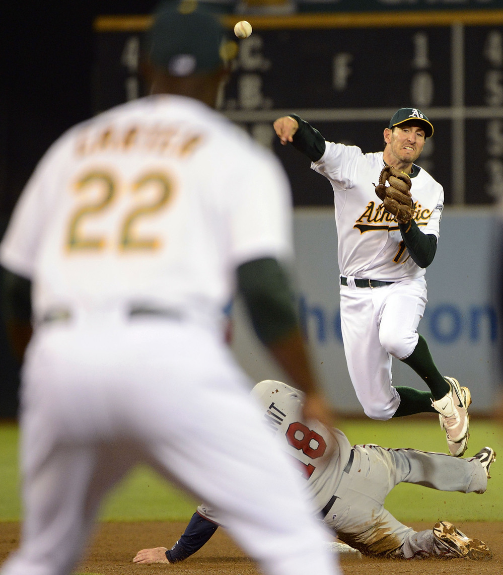 Adam Rosales of the Oakland Athletics gets his throw off to Chris Carter at first base to complete Tuesday night's triple play.