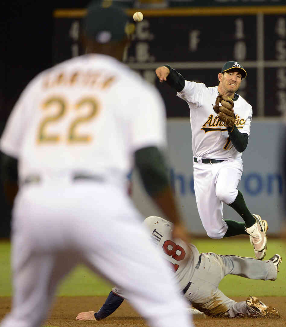 Adam Rosales of the Oakland Athletics gets his throw off to Chris Carter at first base to complete Tuesday night's triple play.