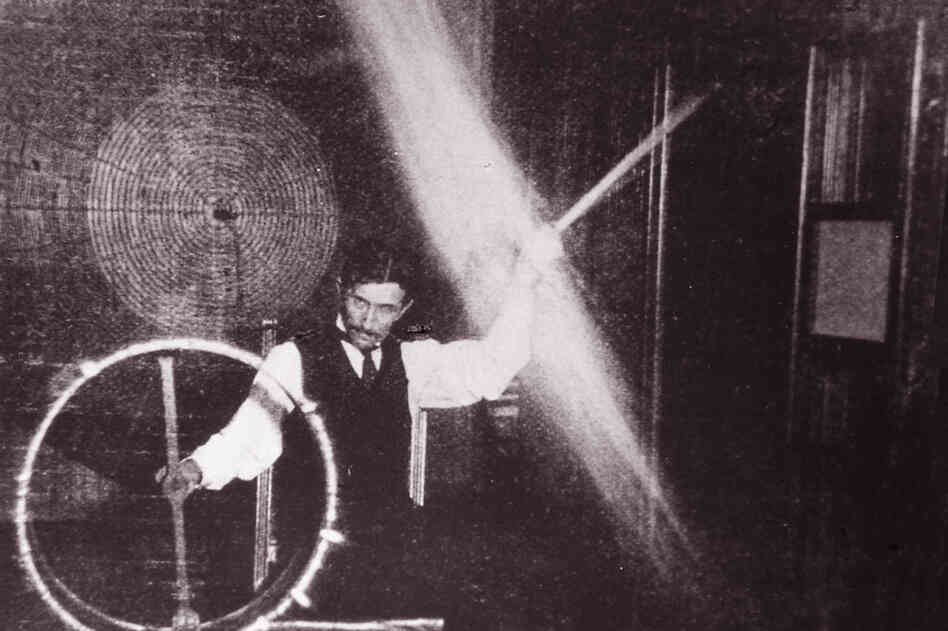 In this photo from 1898, Tesla is sending 500,000 volts through his body to light the lightbulb as he spins it around above his head.