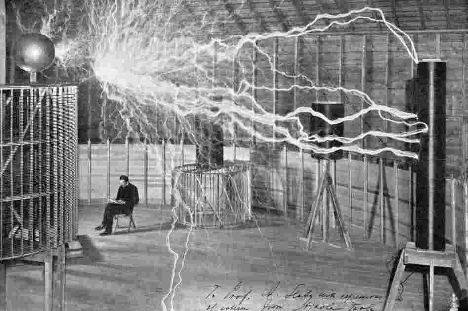 At a laboratory in Colorado Springs, Colo., Nicola Tesla worked with a magnifying transmitter, a device he used to conduct experiments in sending electricity without wires. This image, from around 1900, is a double exposure; the man sitting in the chair wasn't present when the electricity was discharged.