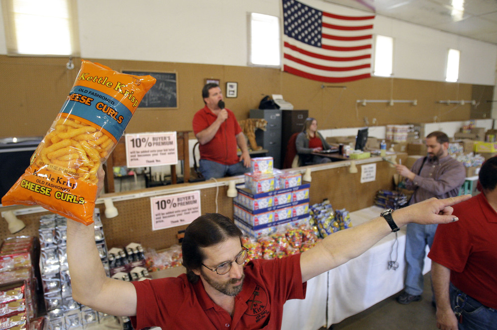 Runner Tom Howard holds up the merchandise at a grocery auction in Dallas, Pa., in 2009. These auctions are becoming more popular as people look for deals on food that's past its prime.