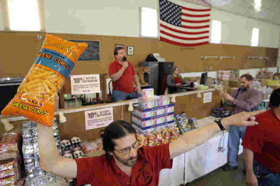 Runner Tom Howard holds up the merchandise at a grocery auction in Dallas, Pa., in 2009. These auctions are becoming more popular as people look for deals on food that's past its prime.