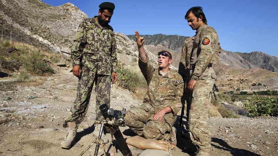 Spc. Ben Purvis (center) helps train Afghan troops on how to use mortars in the eastern province of Kunar in June. The top U.S. commander in Afghanistan, Gen. John Allen, points to several factors in the rise of "insider attacks" on American forces. He says relations between U.S. and Afghan troops are good overall.