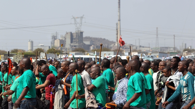 Mine workers attend a memorial service in South Africa Thursday, Aug. 23, for miners killed last week by police officers.
