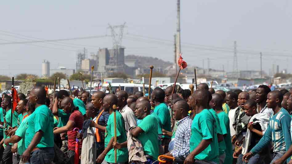 Mine workers attend a memorial service in South Africa Thursday, Aug. 23, for miners killed last week by police officers.
