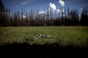 Madison Daniels, a student at Northern Arizona University, takes a short break from gathering data in a meadow in Apache-Sitgreaves. Both students and faculty live in the forest for weeks while they conduct their ecological research.