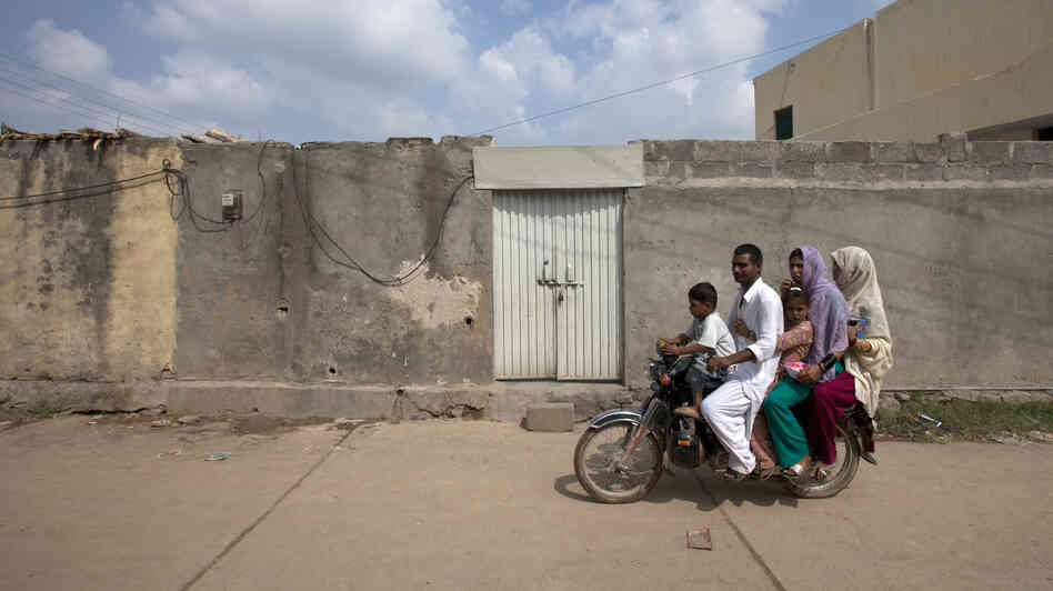 A family rides past the house of Rimsha Masih, a Pakistani Christian girl arrested on blasphemy charges, on the outskirts of Islamabad, Pakistan, on Thursday. Rimsha is accused of burning pages of Quranic verse — a crime punishable by death in Pakistan. Her case has reignited debate over the country's blasphemy law and the growing influence of Muslim extremists.
