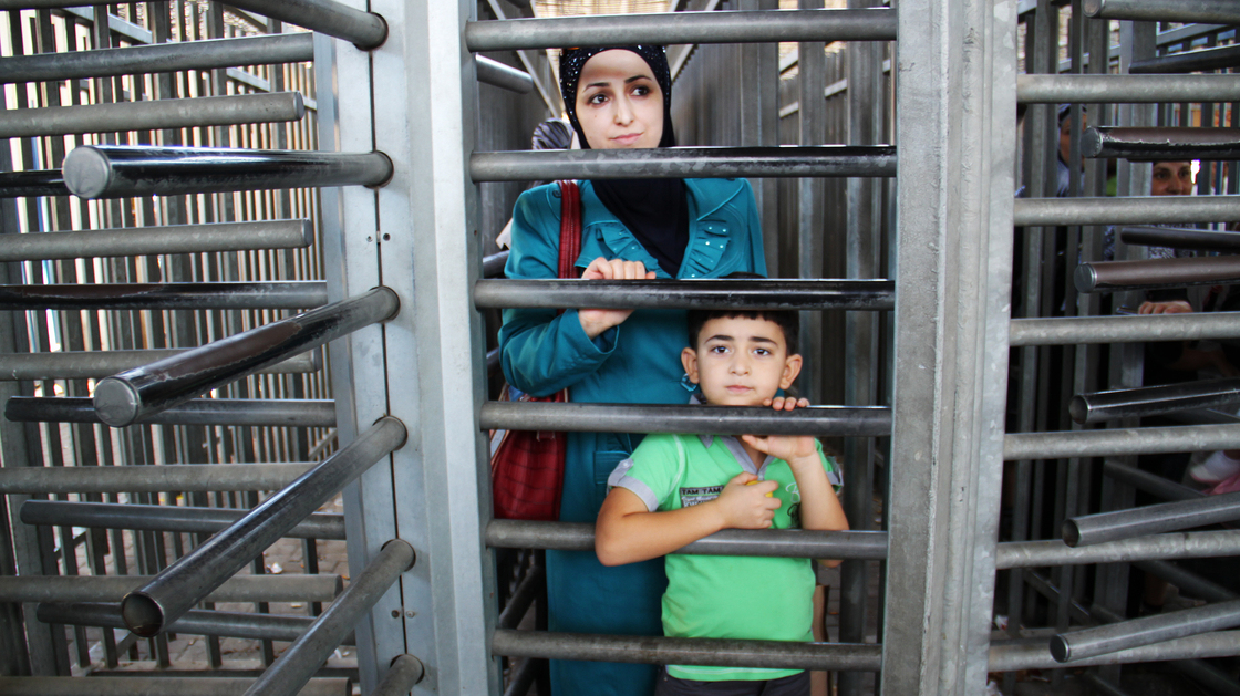 A mother and son wait to enter Israel through the Qalandia checkpoint, which separates the West Bank and Jerusalem. Most of the year, Israel permits relatively few Palestinians to visit, but over the Muslim holy month of Ramadan, 1.2 million Palestinians were allowed in.