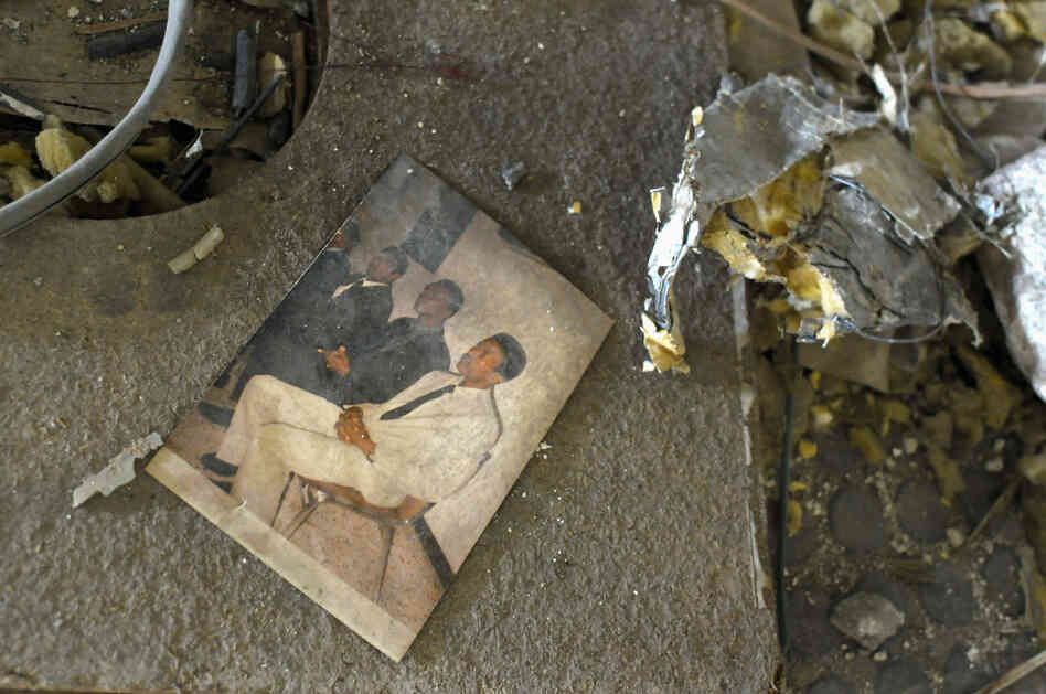 A photograph lies amid the rubble.