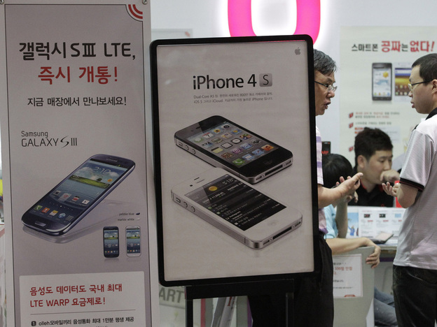 Banners advertising Samsung Electronics' Galaxy S III and Apple's iPhone 4S are displayed at a store in Seoul, South Korea.