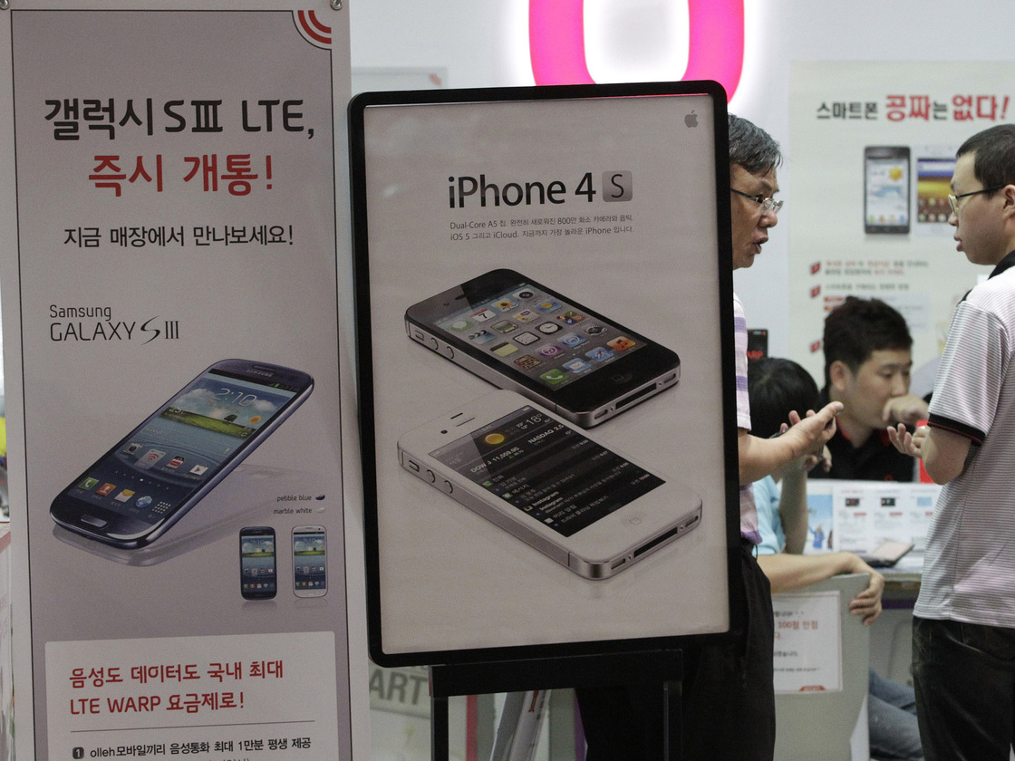 Banners advertising Samsung Electronics' Galaxy S III and Apple's iPhone 4S are displayed at a store in Seoul, South Korea.