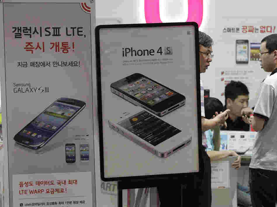 Banners advertising Samsung Electronics' Galaxy S III and Apple's iPhone 4S are displayed at a store in Seoul, South Korea.